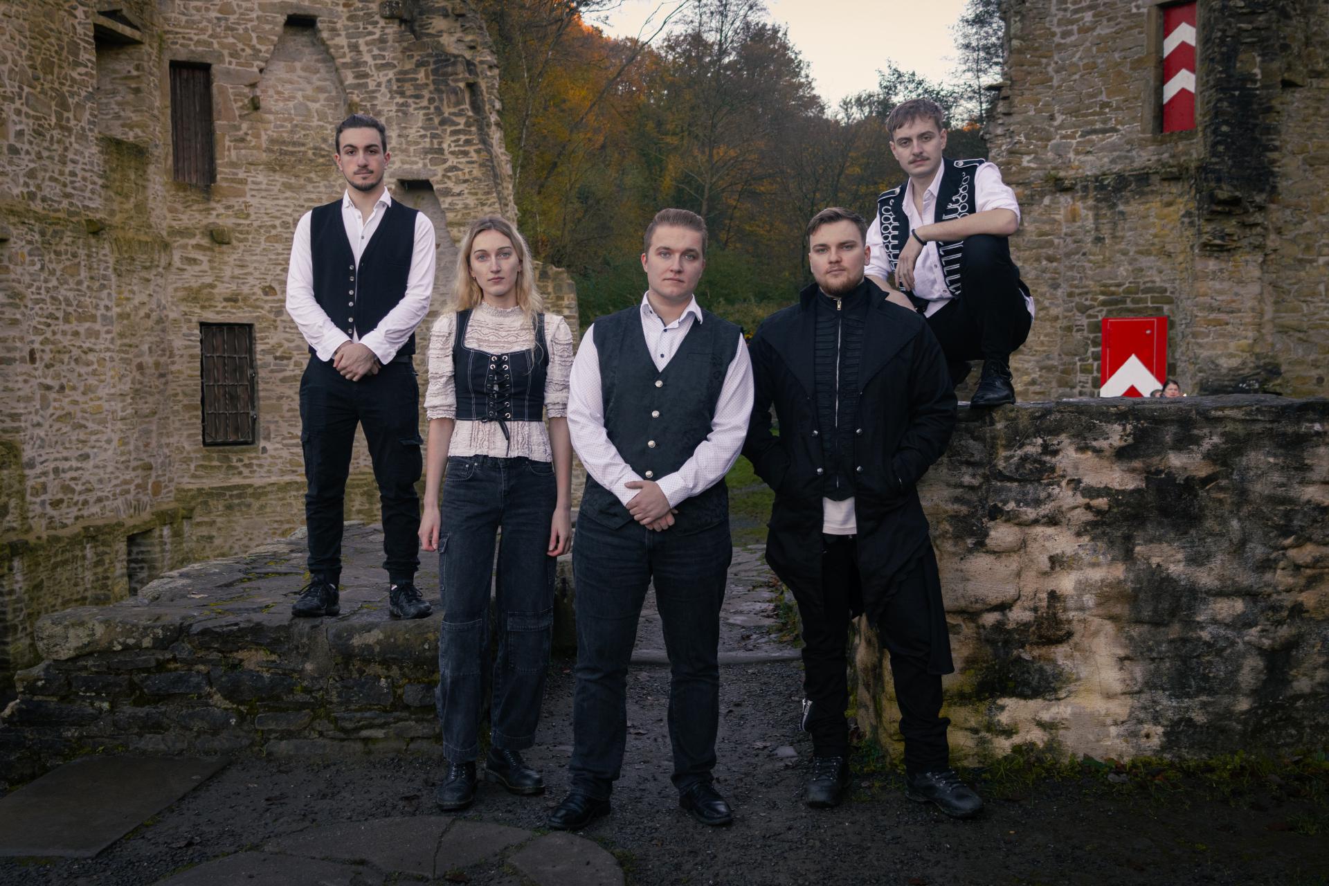 Die fünf Musiker von Becoming Wind stehen in einer Burgruine.