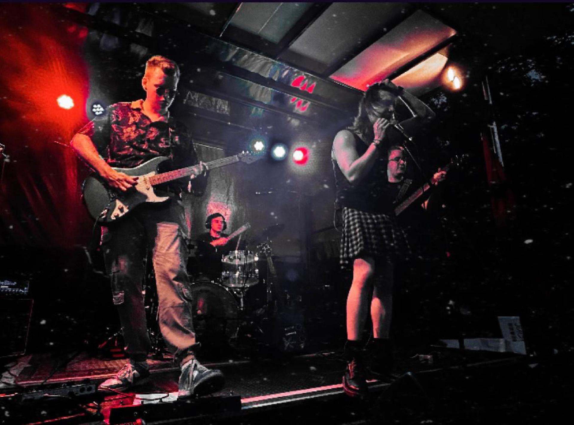 Vier Bandmitlgieder spielen live auf einer Open Air Bühne