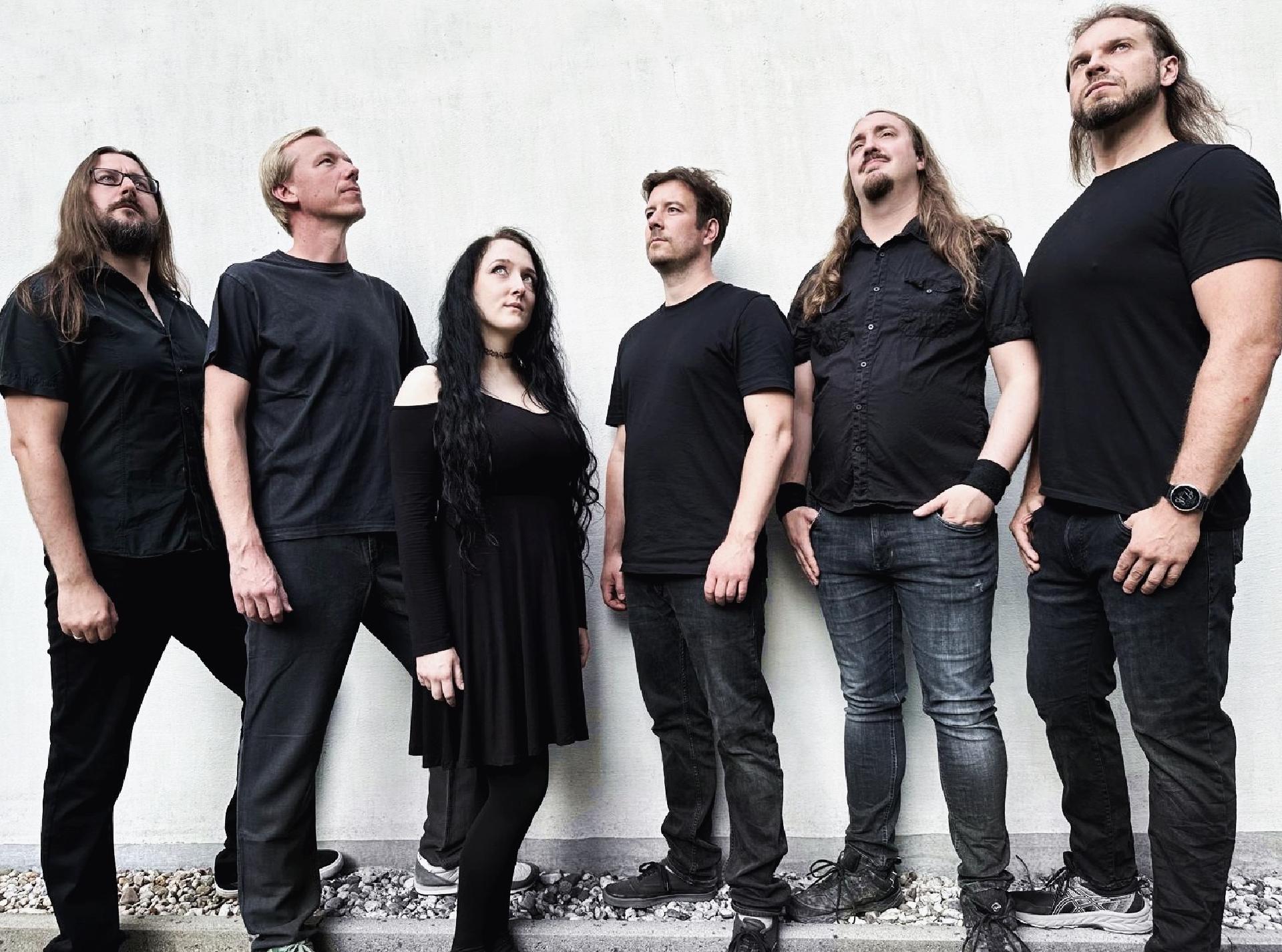 Die Band Metascope, 6 Personen die vor einer Wand stehen. 5 Männer und eine Frau, ohne Instrumente.