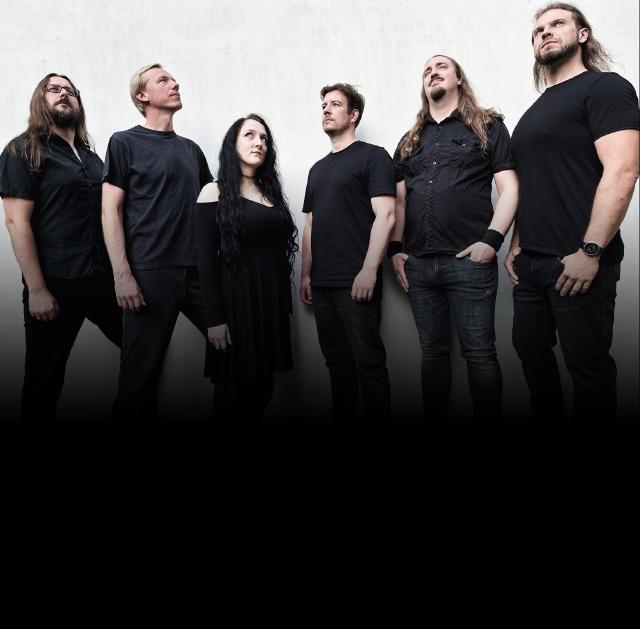 Die Band Metascope, 6 Personen die vor einer Wand stehen. 5 Männer und eine Frau, ohne Instrumente.