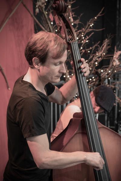 Steffen mit einem Kontrabass in der Hand.